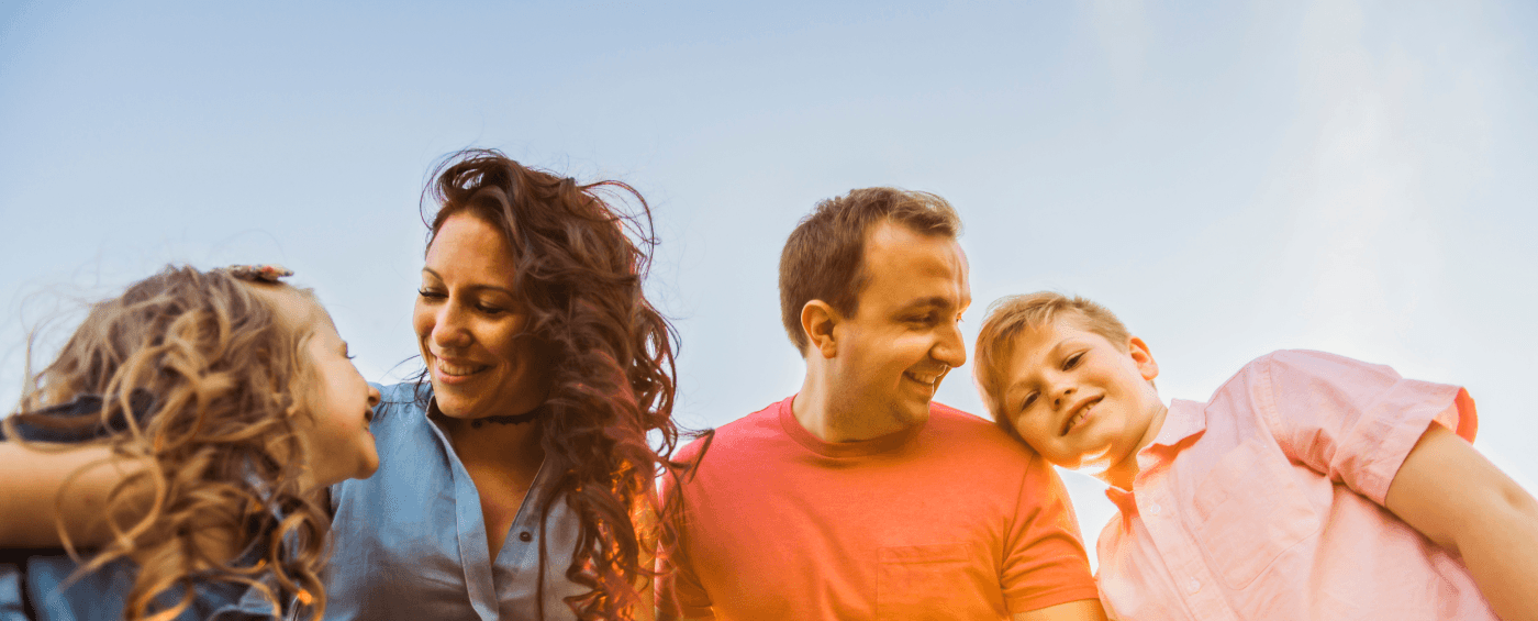 A family of four smiling together